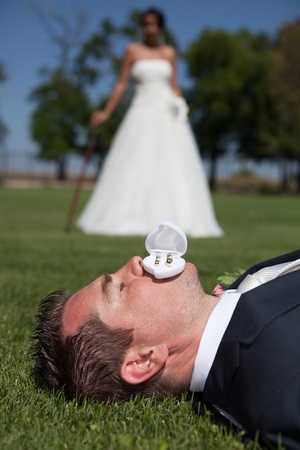 Wedding rings and groom  Bride standing in background の写真素材