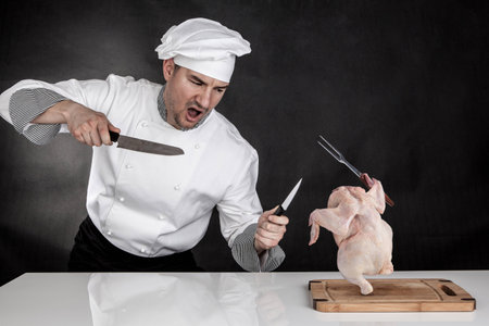 Angry cook fighting with knifes  Raw chicken attackの写真素材