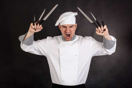 Angry chef with knifes on black backgroundの写真素材