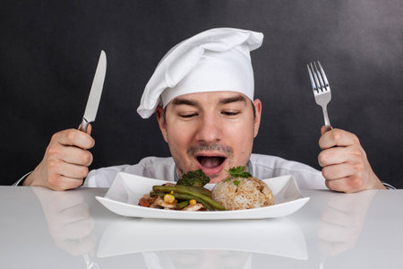 Chef eating his prepared food with cutlery  Black backgroundの写真素材