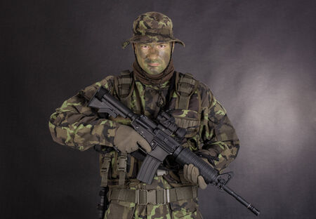Soldier in camouflage and modern weapon M4 on black の写真素材