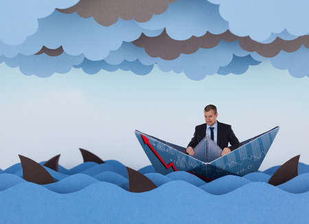 Businessman surrounded by sharks in stormy sea. Competitive business concept. Paper waves, clouds, boat and sharks.の写真素材