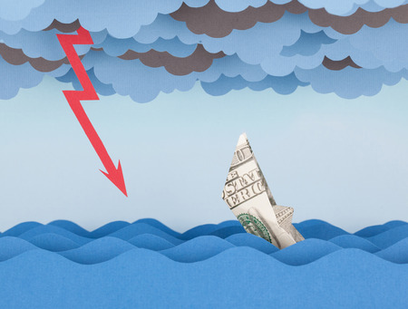 Dollar boat in storm. Money ship is sinking into paper sea.の写真素材
