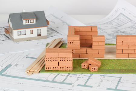 Model house construction with brick on blueprintの写真素材