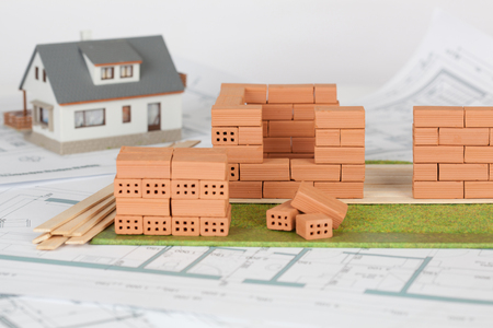 Model house construction with brick on blueprintの写真素材