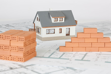 Model house construction with brick on blueprintの写真素材