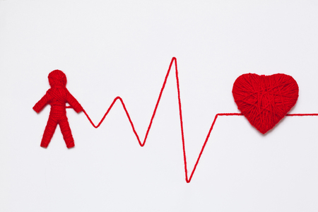 red yarn heart and human figure with thread like ECG pattern, isolated on white backgroundの写真素材