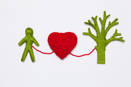 Yarn red heart, green tree and human figure isolated on white. Ecology conceptの写真素材