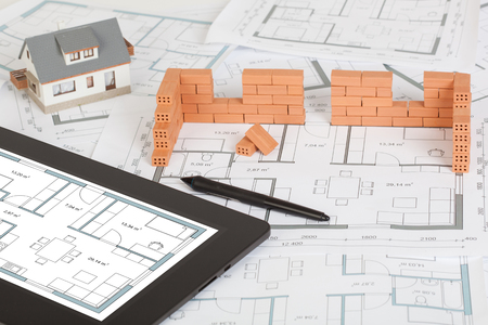 Model house construction with brick on blueprint and tabletの写真素材