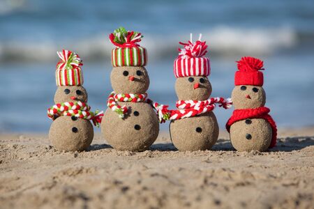 Family of sandy Snowmen at tropical beach. Holiday concept - New Year's and Christmas Cards の写真素材