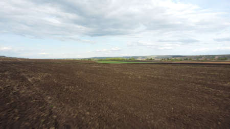 Background of brown earth at high altitude aerial view. Aerial drone view of freshly plowed field ready for seeding and planting in spring.の写真素材