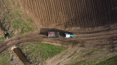 Aerial view of the tractor in the field, agricultural field work, sowing work in the field at sunsetの写真素材