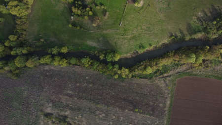 Aerial view to spring landscape with green fields, bright trees and blue sky.の写真素材