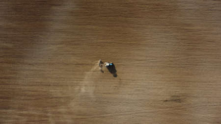 Aerial view of the tractor in the field, agricultural field work, sowing work in the field at sunsetの写真素材