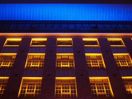 Beautiful brick building illuminated in yellow, red and blue