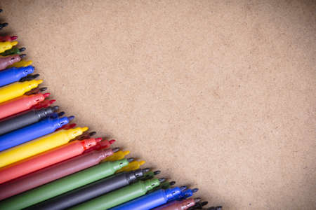 colored pens on a brown backgroundの写真素材