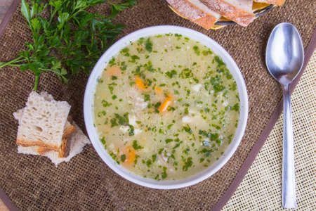 traditional barley soup in a white bowl with breadの写真素材