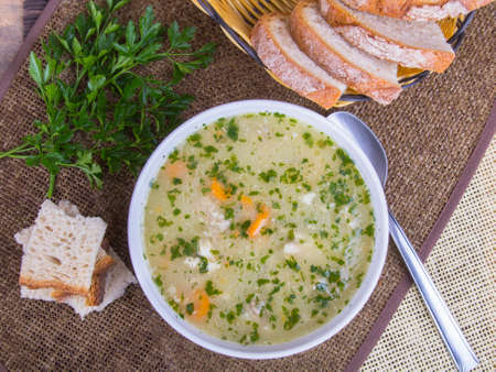 traditional barley soup in a white bowl with breadの写真素材