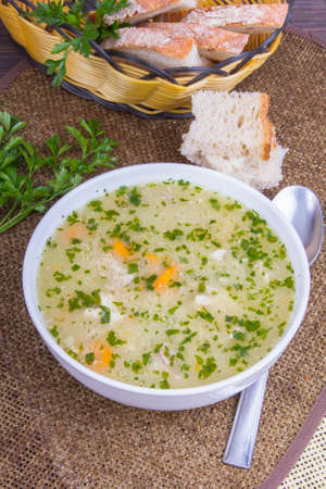 traditional barley soup in a white bowl with breadの写真素材