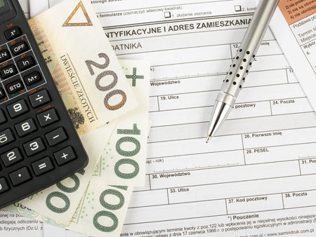 Filling in polish individual income tax form PIT with money and pen