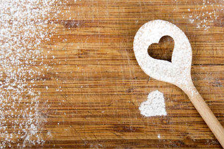 Heart hole on the wooden spoon pastry board - baking backgroundの写真素材