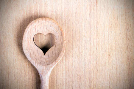 Heart hole on the wooden spoon pastry board - baking backgroundの写真素材