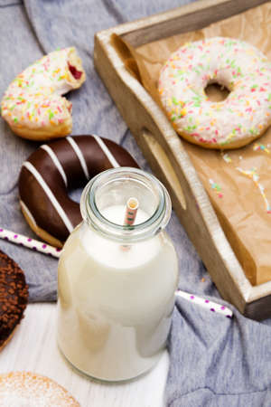 Bottle of milk and colorful donuts with chocolate and icing, selective focusの写真素材
