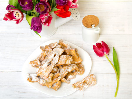 Faworki - Traditional Polish cookies served at Fat Thursday.  Cookies and tulip bouquet on white...