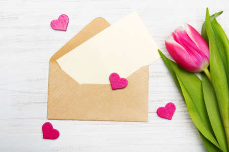 Tulip and envelope on white wooden background, copy spaceの写真素材