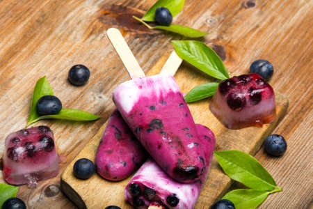 Tasty homemade blueberries ice cream on wooden background. Organic fruit popsicles.の写真素材
