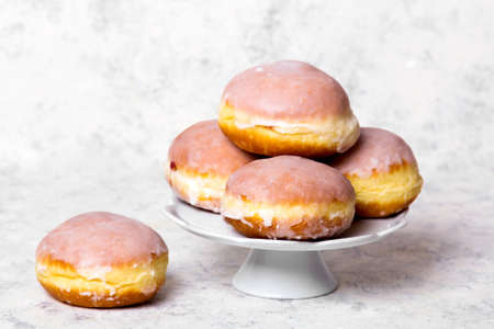 Traditional Polish donuts with frostng on light background. Tasty doughnuts with jam.の写真素材