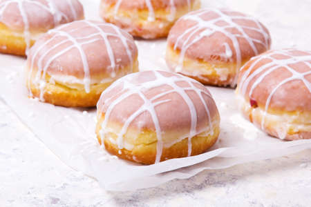 Traditional Polish donuts with white frosting on white background. Tasty doughnuts with jam.の写真素材