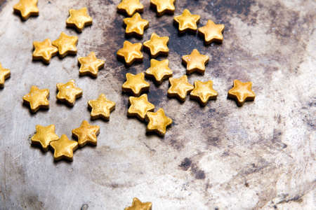 Small golden stars on a old metal background, copy spaceの写真素材