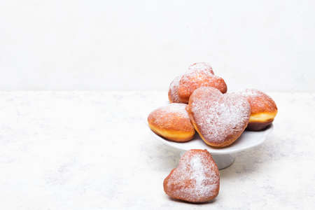 Homemade heart shaped donuts with powdered sugar on whiteの写真素材