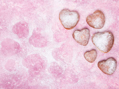 Homemade heart shaped donuts with powdered sugar on pinkの写真素材
