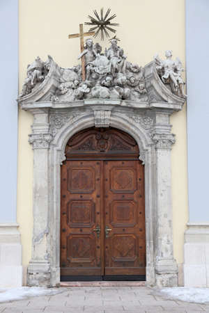 Entrance to a church in Budapest, Hungary   Wooden door with stone statuettes above it の写真素材