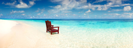Wooden chair standing in the sea on the beach invitation to rest on a deserted island alone, a wide panoramic view of the oceanの写真素材