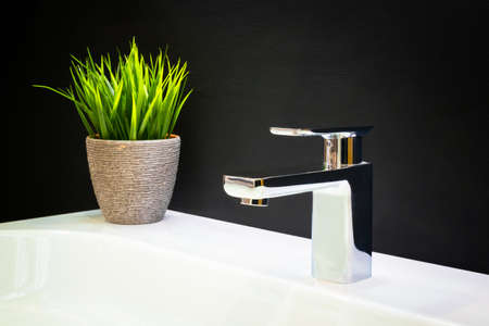 Luxury faucet mixer on a white sink in a beautiful dark bathroomの写真素材