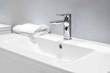 Luxury faucet mixer on a white sink in a beautiful gray bathroomの写真素材