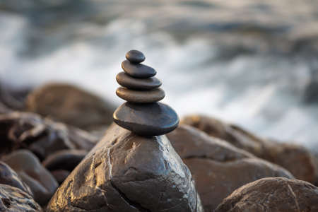 Stones pyramid on pebble beach symbolizing stability, harmony, balance. Shallow depth of field.の写真素材