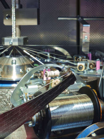 Manufacture of metal shielding braids for electrical cables. High-speed braiding machine. Winding the finished braid over the reel.の写真素材