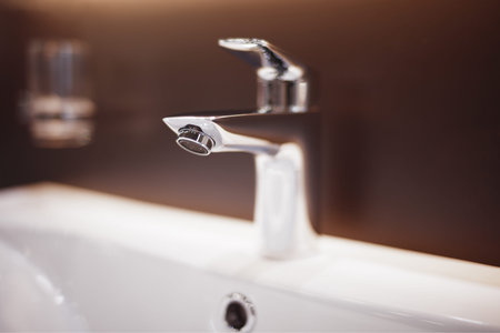 Luxury faucet mixer on a white sink in a beautiful bathroom, shallow depth of fieldの写真素材