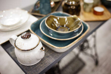 vintage white teapot and utensils on a wooden tableの写真素材