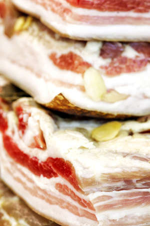 Fat pork with garlic and bay leaves large chunks closeup vertical backgroundの写真素材