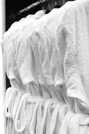 white bathrobes, pillows, towels, hanging in wooden closet of service room in hotelの写真素材