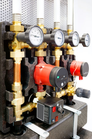 Close up of manometer, pipe, flow meter, water pumps and valves of heating system in a boiler roomの写真素材