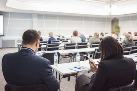 Business man and woman with and people listening on the conference or on the training in the hallの写真素材