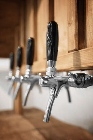 Raw of beer crane macro close-up blurred background. Wooden vintage retro style vertical imageの写真素材