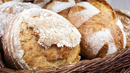 Wicker basket with bread. Bread and buns inside basket. Fresh bakery products on table. Tastes best...