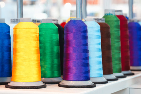 Bobbins with colored thread for industrial textile machines